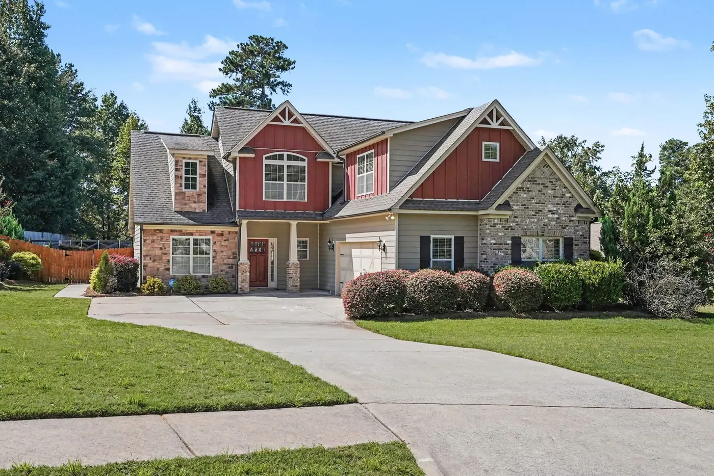 Front of 139 Caraway Road, a two story home with a stone and siding front, a long driveway and a wide lawn