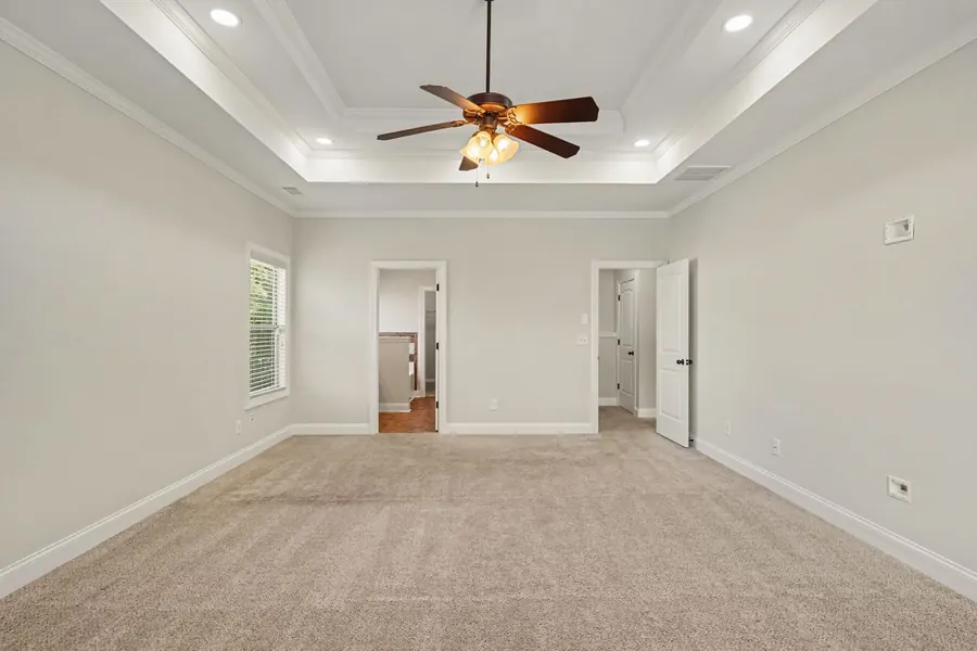 Bedroom with a tray ceiling and wide window