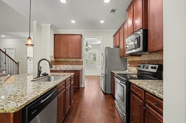 Granite counters and wood cabinetry along the kitchen wall