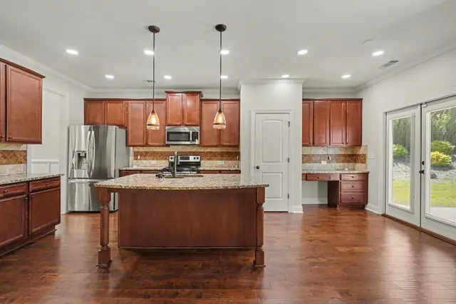 Kitchen with a large island, pendant lights and stainless appliances