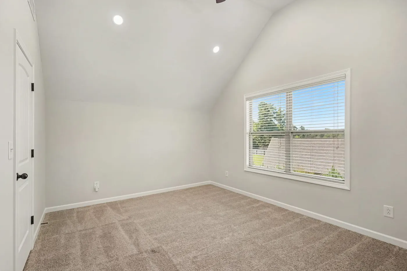 Sunny bedroom with a large window and soft carpet